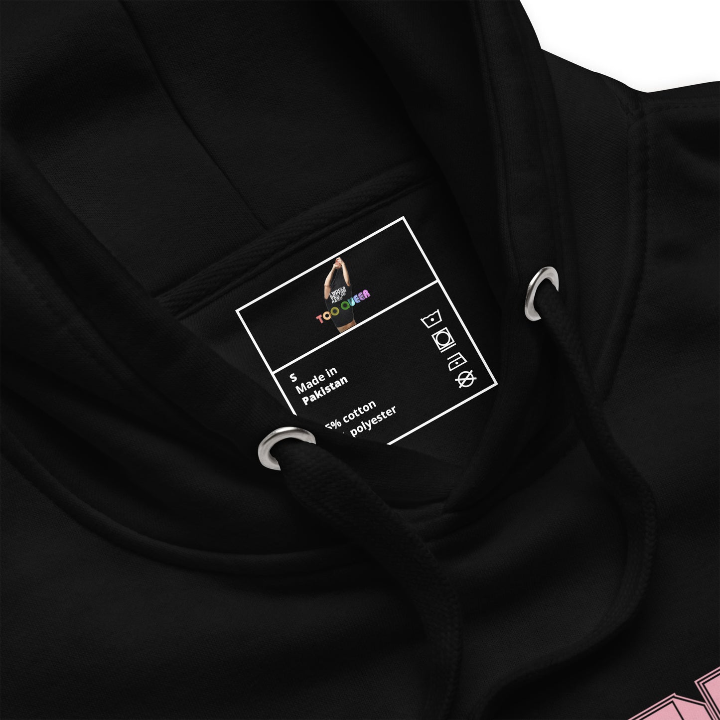 Close-up of a black hoodie showing the inner neck label with 'TooLoud' branding and 'Made in Pakistan' text, along with metal drawstring rings.