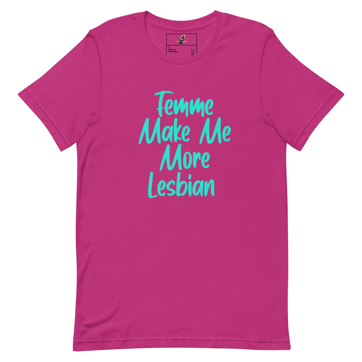 A bright pink short-sleeve t-shirt with the phrase 'Femme Make Me More Lesbian' printed in a light blue cursive font across the chest, displayed on a clean white background.