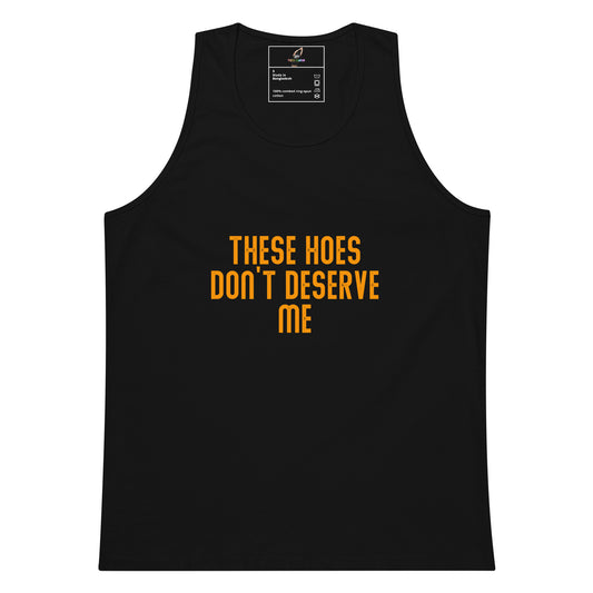 A black sleeveless tank top with the phrase 'THESE HOES DON'T DESERVE ME' printed in bold orange letters on the front, shown against a plain white background.