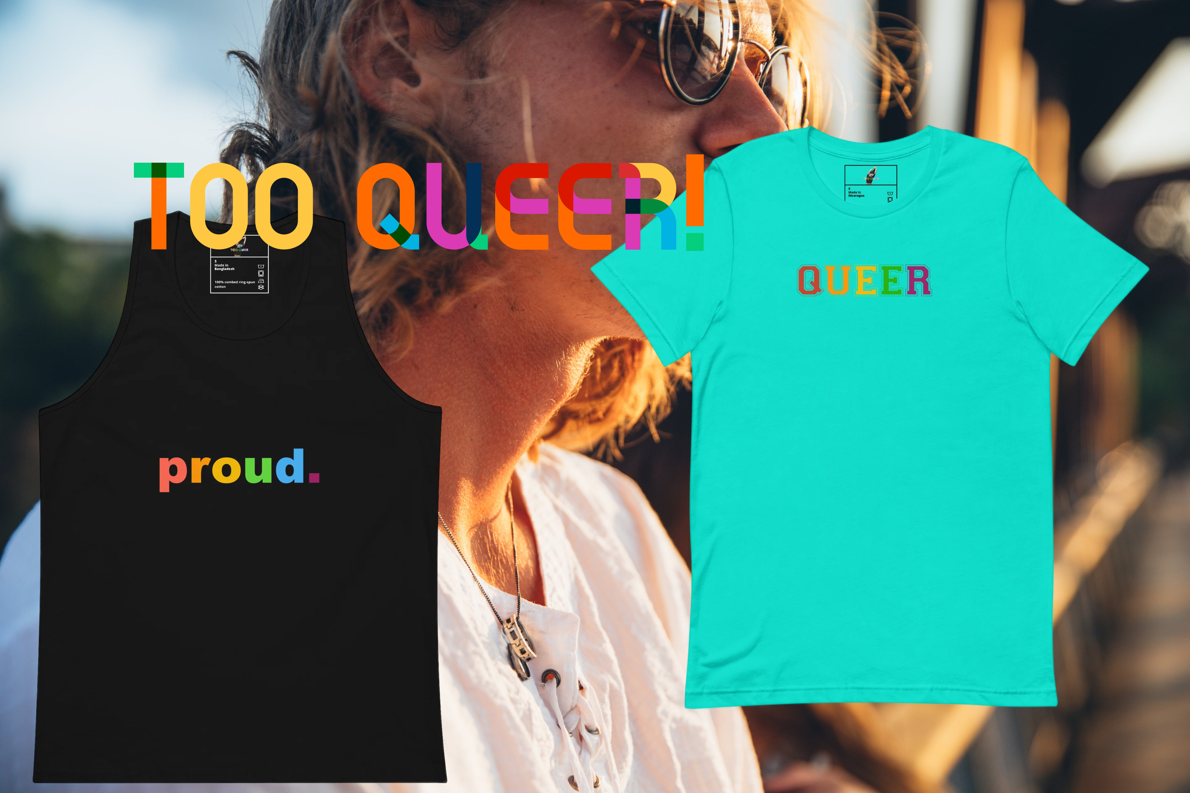 Two graphic apparel items shown against a blurred outdoor portrait background: a black tank top with the word 'proud.' in rainbow letters on the front, and a bright aqua short-sleeve T-shirt with the word 'QUEER' in rainbow letters on the chest.