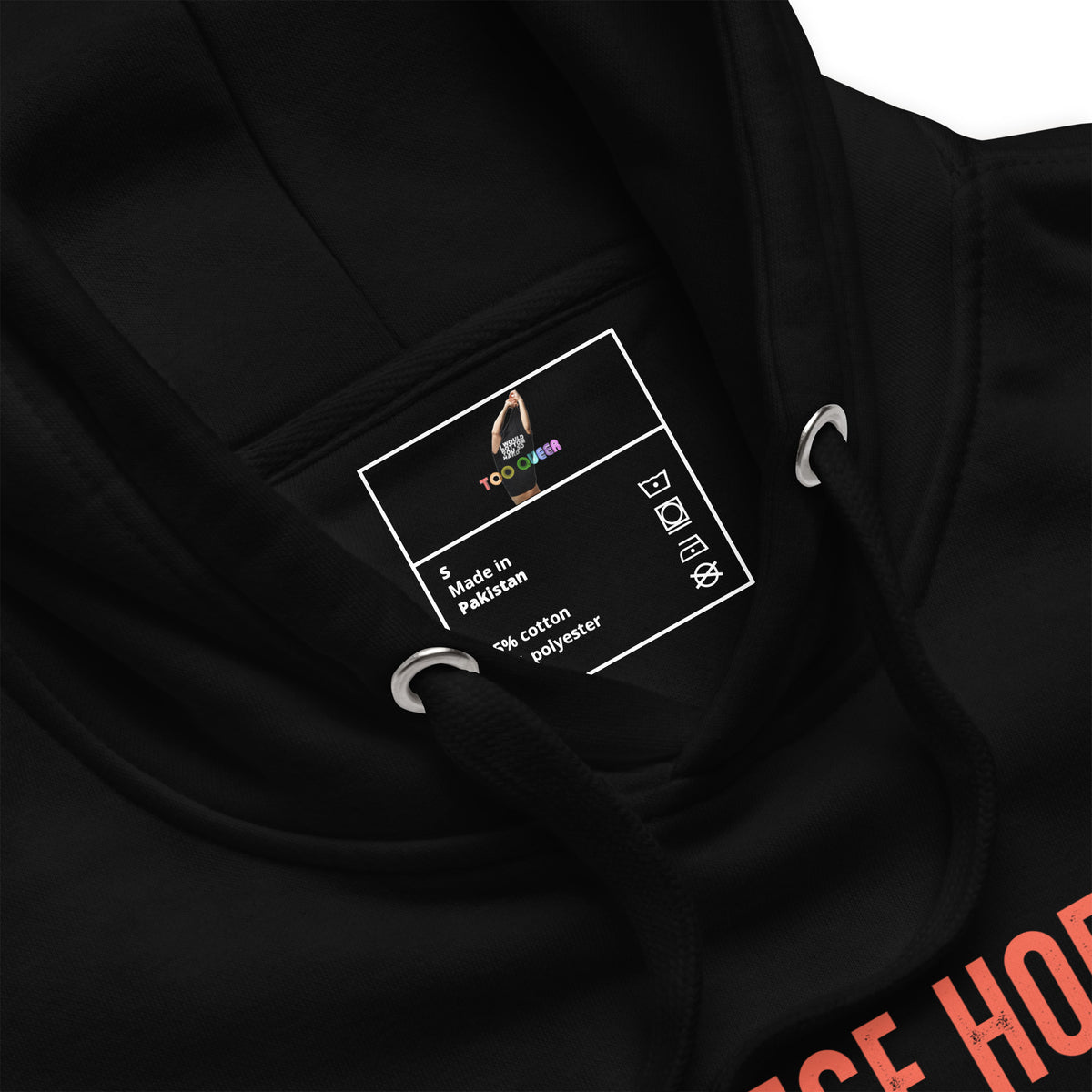 Close-up of a black hoodie showing the inner neck label with 'TooLoud' branding and care instructions, along with metal drawstring rings and a partial orange graphic on the chest.