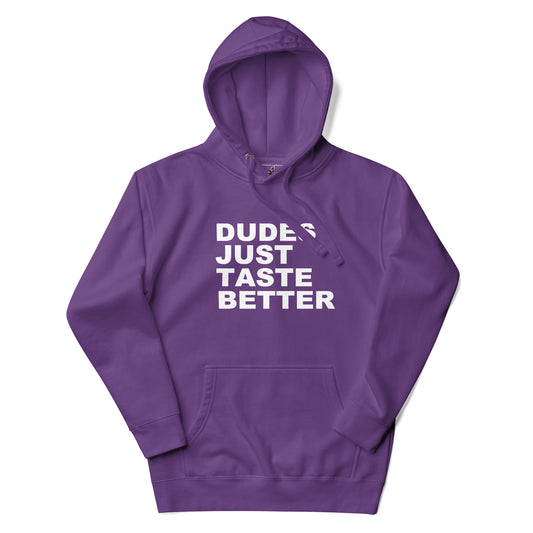 A purple pullover hoodie with a white graphic text print reading 'DUDES JUST TASTE BETTER' on the chest, displayed against a clean white background.