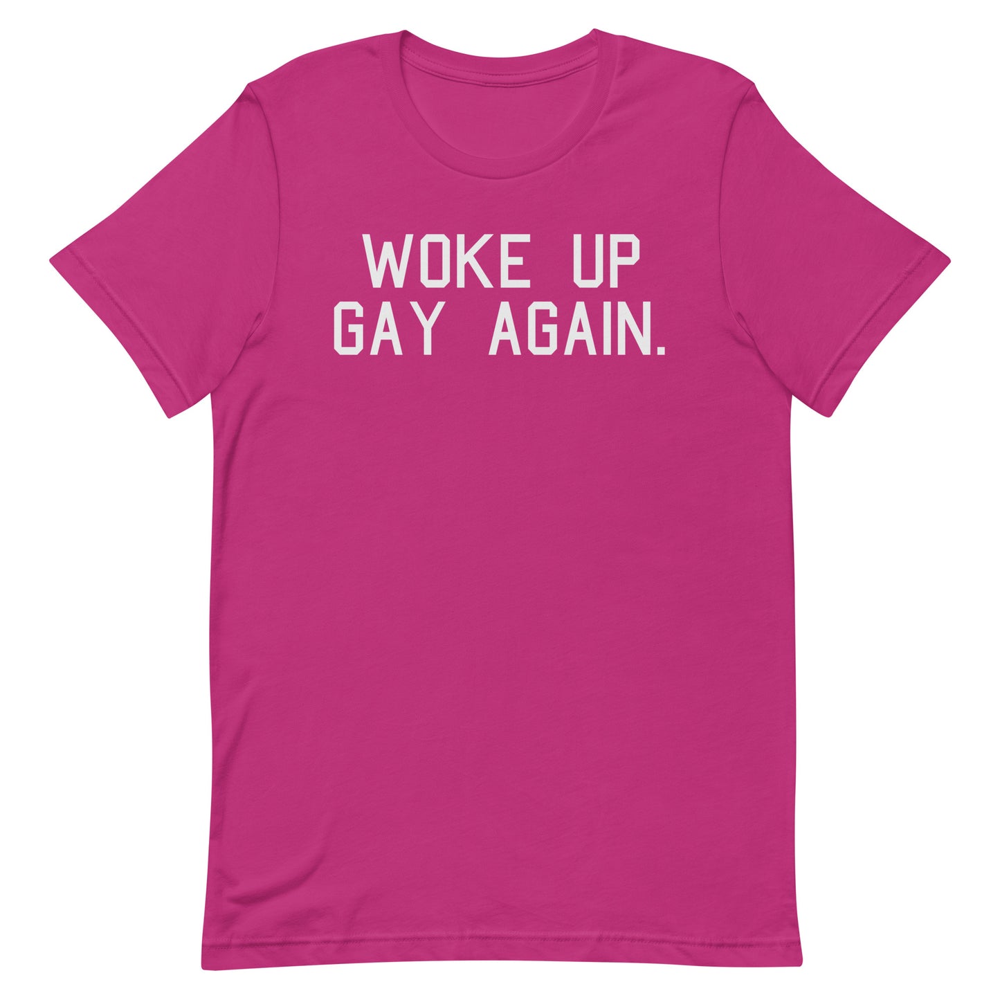 A bright pink short-sleeve t-shirt with the phrase 'WOKE UP GAY AGAIN.' printed in white block letters across the chest, displayed on a clean white background.