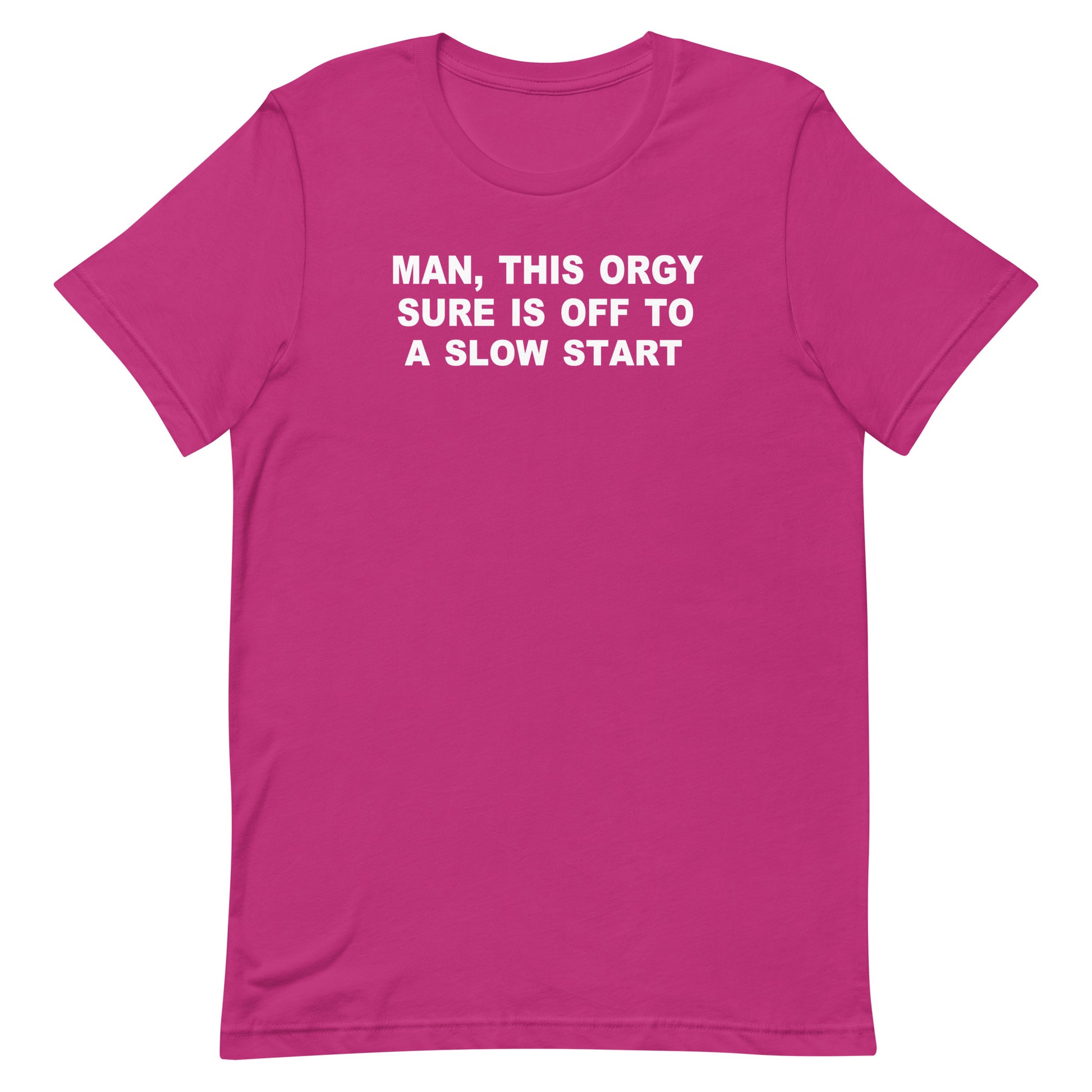 A bright pink short-sleeve crewneck t-shirt with bold white text on the chest that reads 'MAN, THIS ORGY SURE IS OFF TO A SLOW START'. The t-shirt is presented flat against a solid white background.
