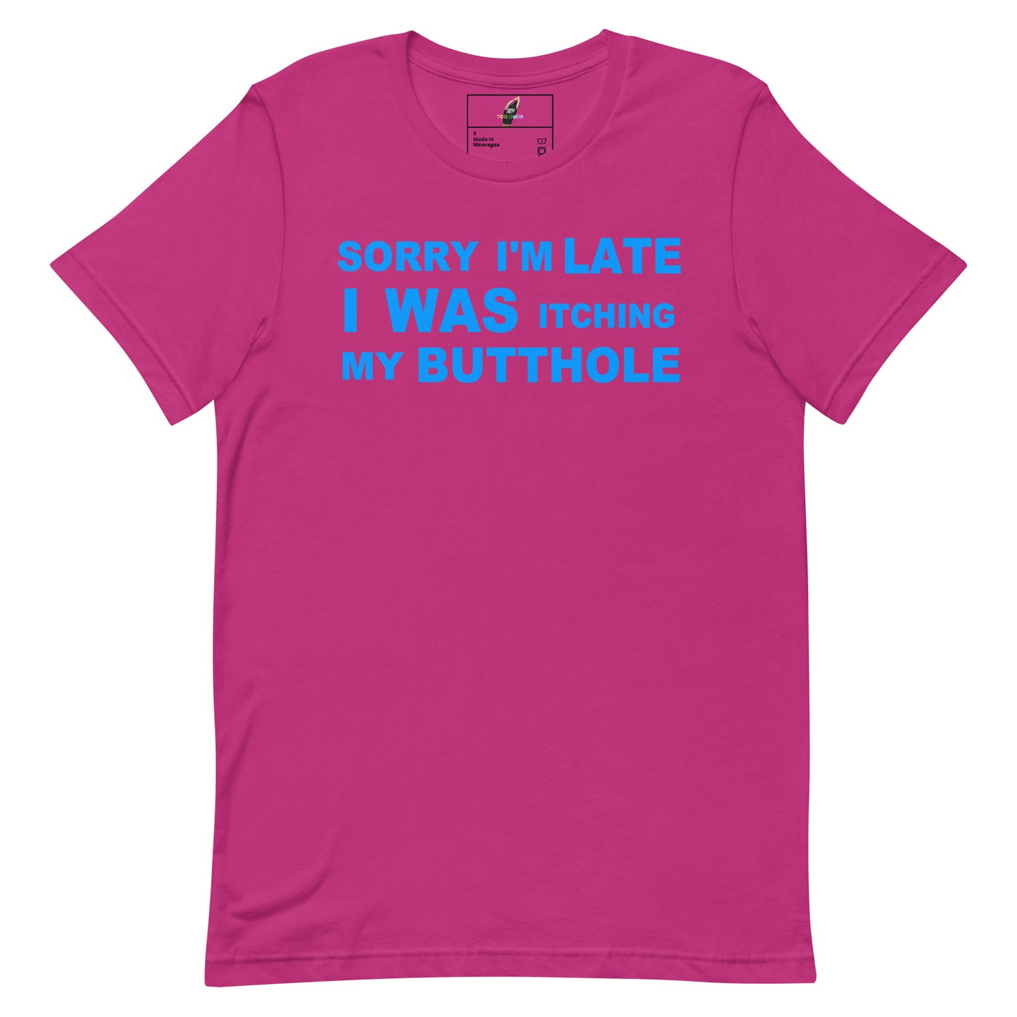 A bright pink short-sleeve t-shirt with a bold blue graphic text on the chest that reads 'SORRY I'M LATE I WAS ITCHING MY BUTTOHOLE'. The t-shirt is displayed flat against a solid white background.