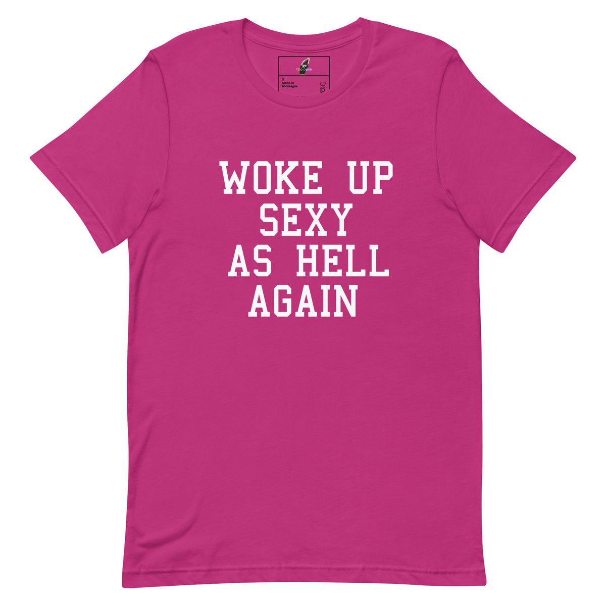A bright pink short-sleeve crewneck t-shirt with the phrase 'WOKE UP SEXY AS HELL AGAIN' printed in white block letters across the chest, displayed flat against a solid white background.