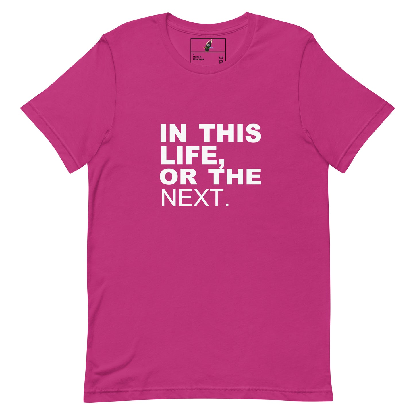 A bright pink short-sleeve crewneck t-shirt with the phrase 'IN THIS LIFE, OR THE NEXT.' printed in bold white capital letters on the chest, displayed on a clean white background.