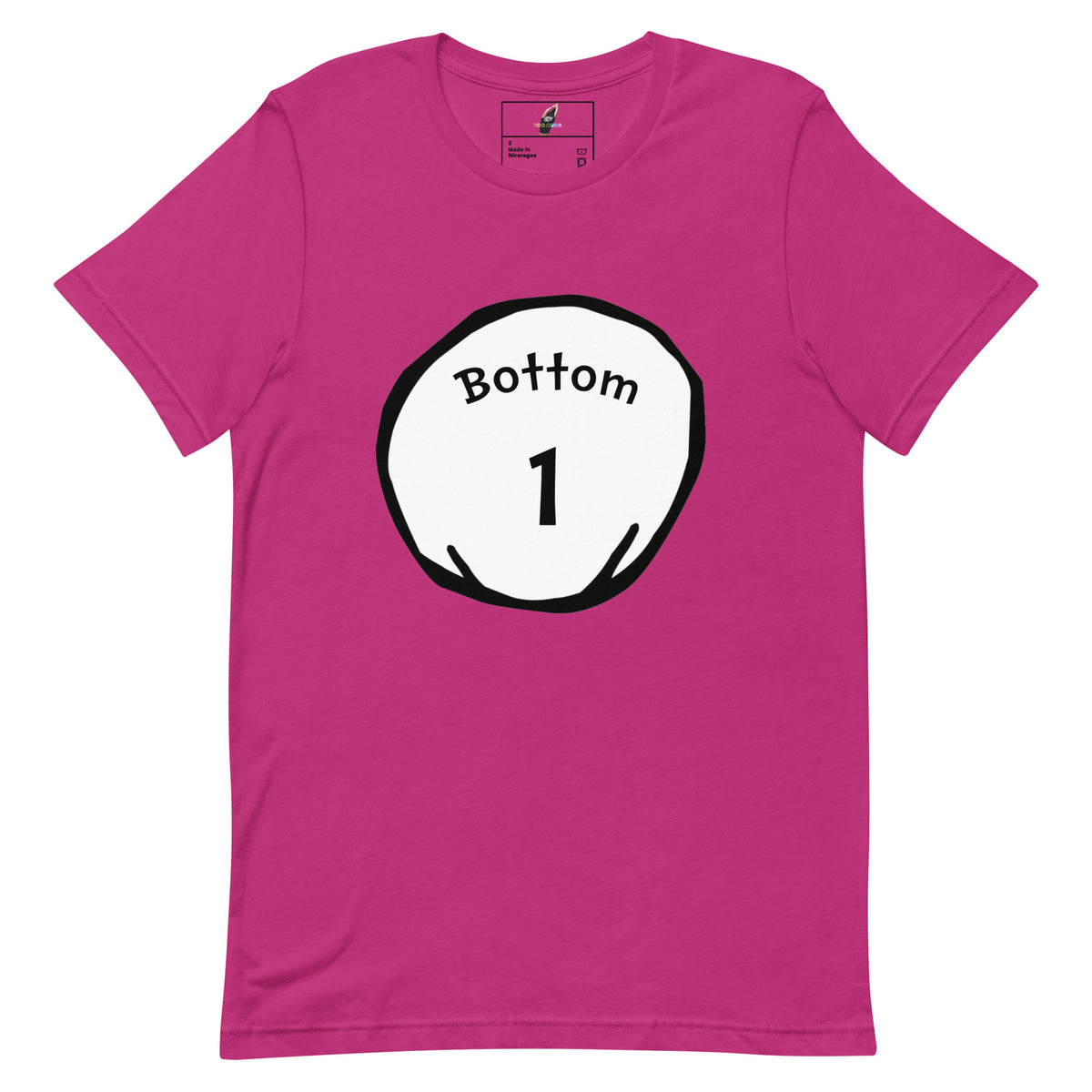 A bright pink short-sleeve crewneck t-shirt with a circular graphic on the chest containing the text 'Bottom 1' in black inside a white circle with a black outline.