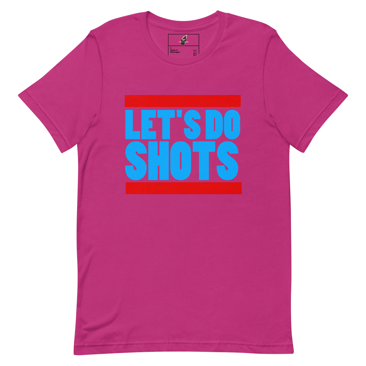 A bright pink short-sleeve t-shirt with a graphic on the chest reading 'LET'S DO SHOTS' in bold blue letters, framed by red horizontal bars, shown on a plain white background.
