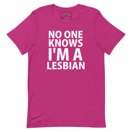 A bright pink short-sleeve t-shirt with bold white text on the front reading 'NO ONE KNOWS I'M A LESBIAN'.