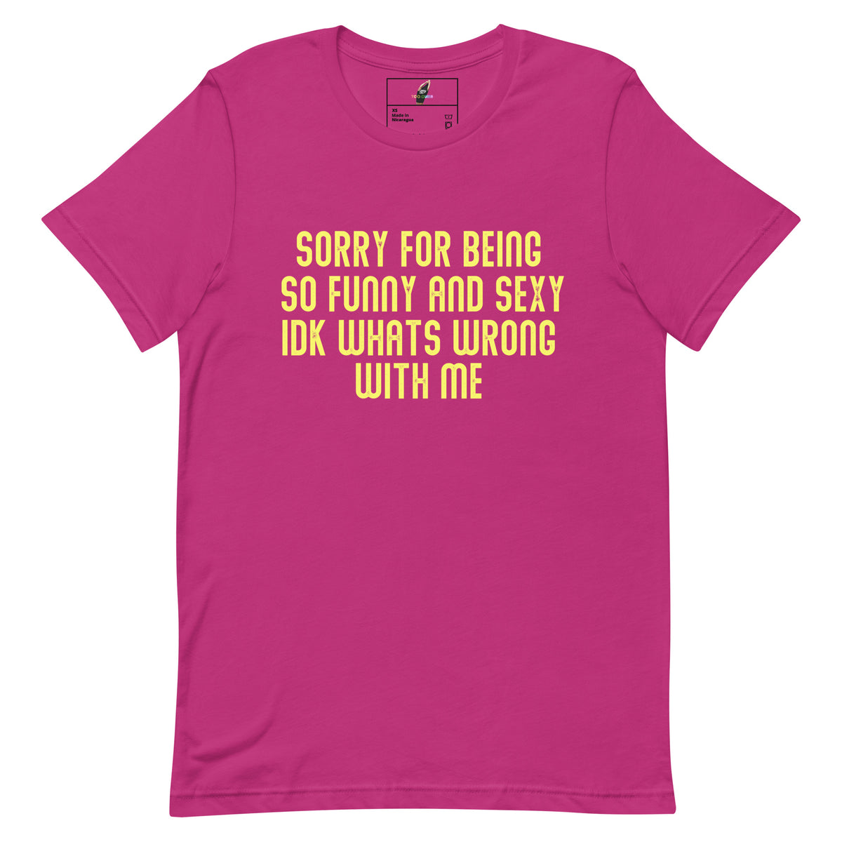 A bright pink short-sleeve t-shirt with yellow text on the front that reads 'SORRY FOR BEING SO FUNNY AND SEXY IDK WHATS WRONG WITH ME'.