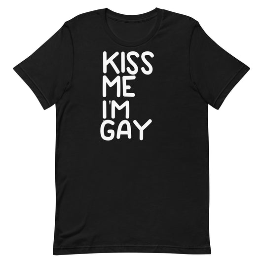A black short-sleeve crewneck t-shirt featuring the text 'KISS ME I'M GAY' printed vertically in white hand-drawn style letters on the front, displayed against a solid white background.