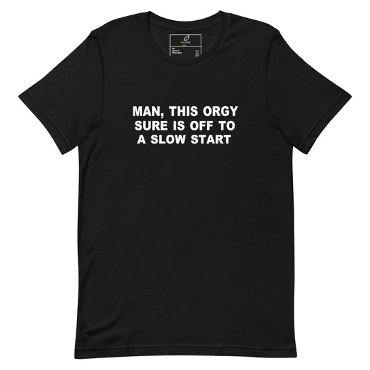 A black short-sleeve crewneck t-shirt with bold white text on the chest that reads 'MAN, THIS ORGY SURE IS OFF TO A SLOW START'. The shirt is displayed flat against a solid white background, with a small brand label visible inside the collar.