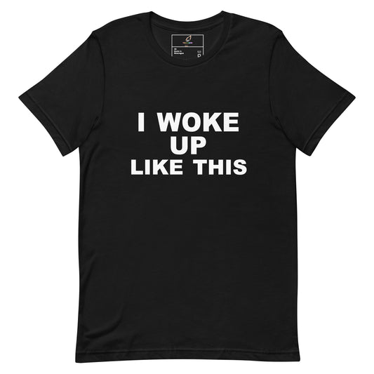 A black short-sleeve crewneck t-shirt with the phrase 'I WOKE UP LIKE THIS' printed in bold white capital letters across the chest, displayed flat against a solid white background.