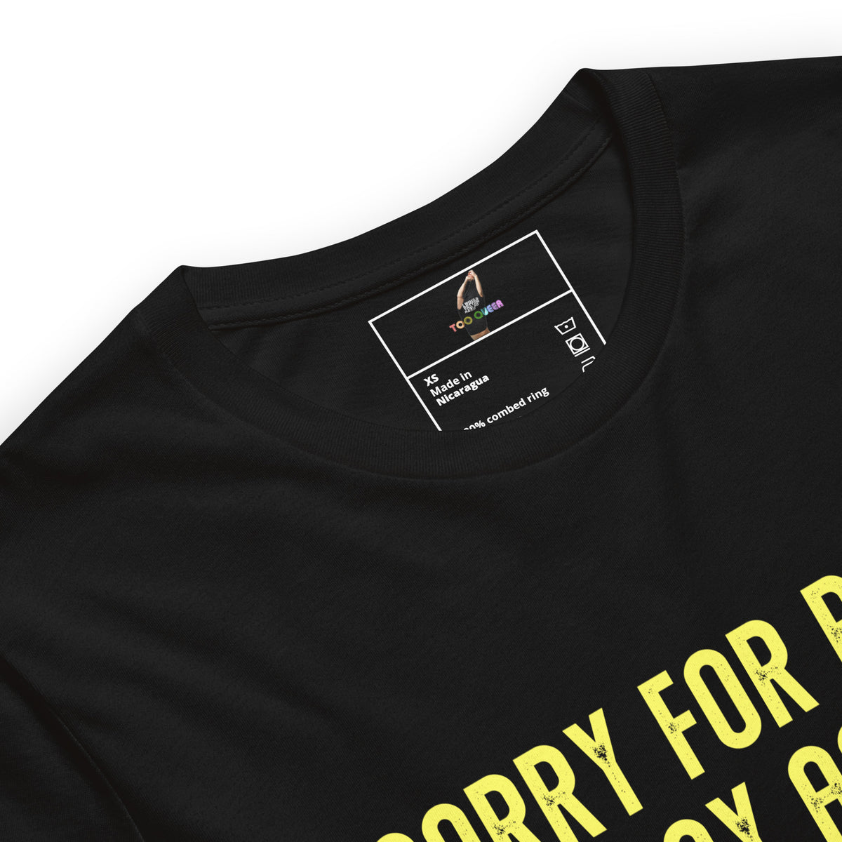 Close-up of a black short-sleeve t-shirt showing the inner neck label and part of a yellow graphic print that reads 'SORRY FOR PEACE' on a white background.