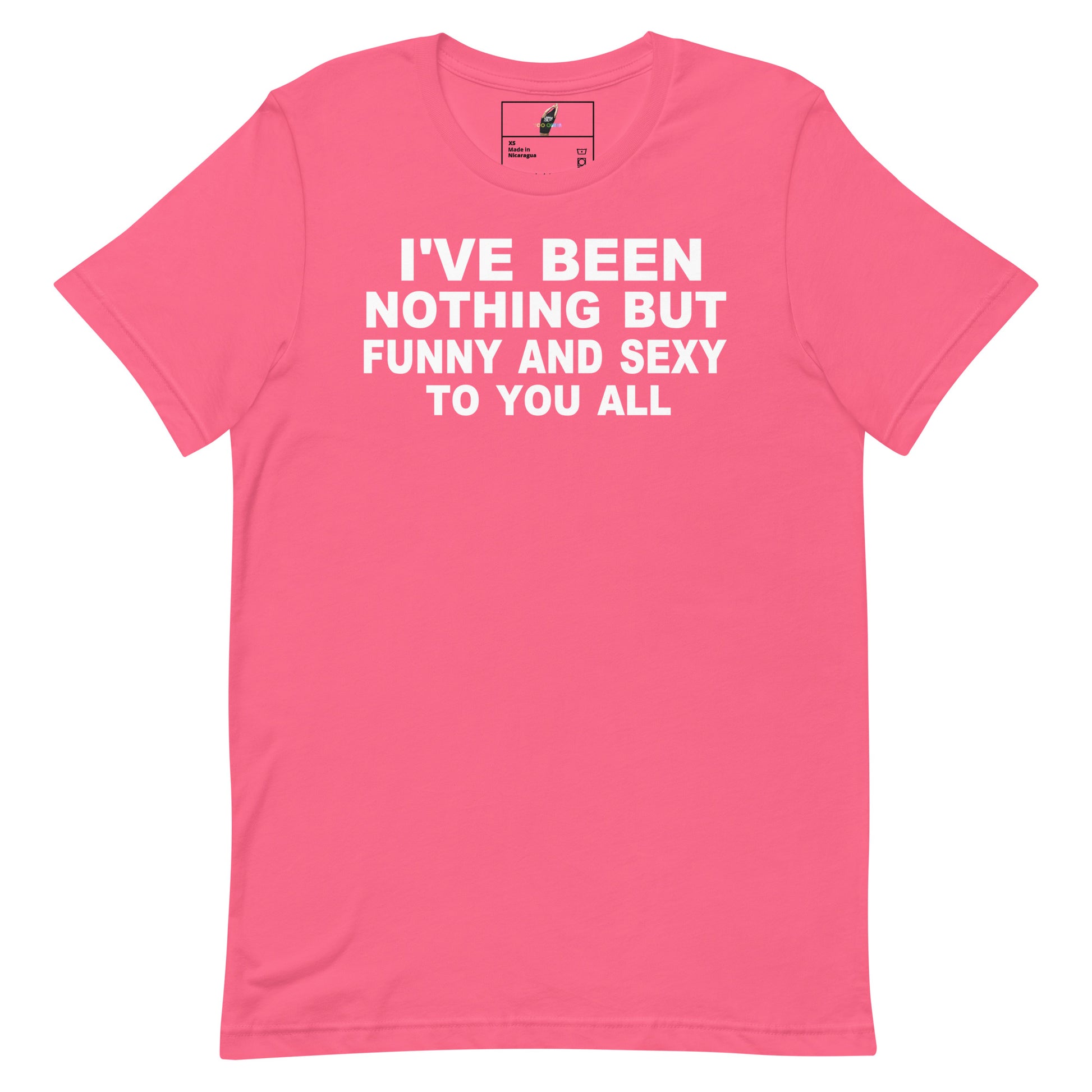 A bright pink short-sleeve t-shirt with bold white text on the front reading 'I'VE BEEN NOTHING BUT FUNNY AND SEXY TO YOU ALL'. The shirt is shown flat against a solid white background, with a small brand label visible inside the collar.