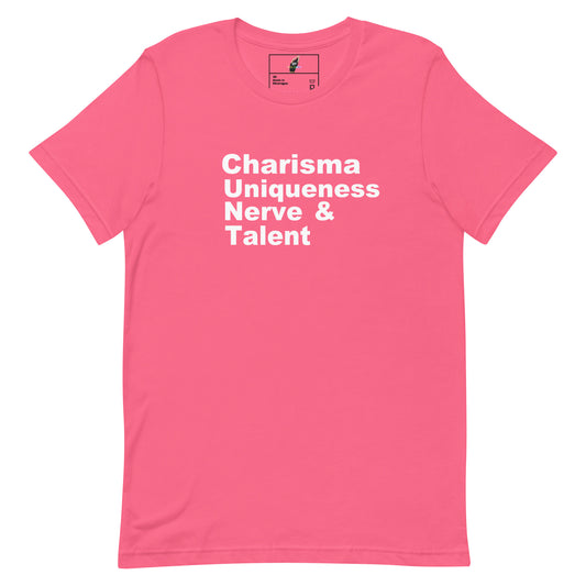 A pink short-sleeve crewneck t-shirt with the words 'Charisma Uniqueness Nerve & Talent' printed in white sans-serif text across the chest, displayed on a clean white background.