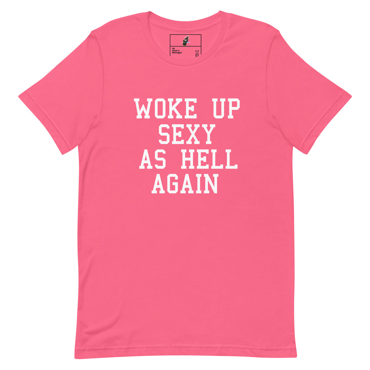 A bright pink short-sleeve t-shirt with the phrase 'WOKE UP SEXY AS HELL AGAIN' printed in bold white block letters across the chest, displayed flat against a plain white background.