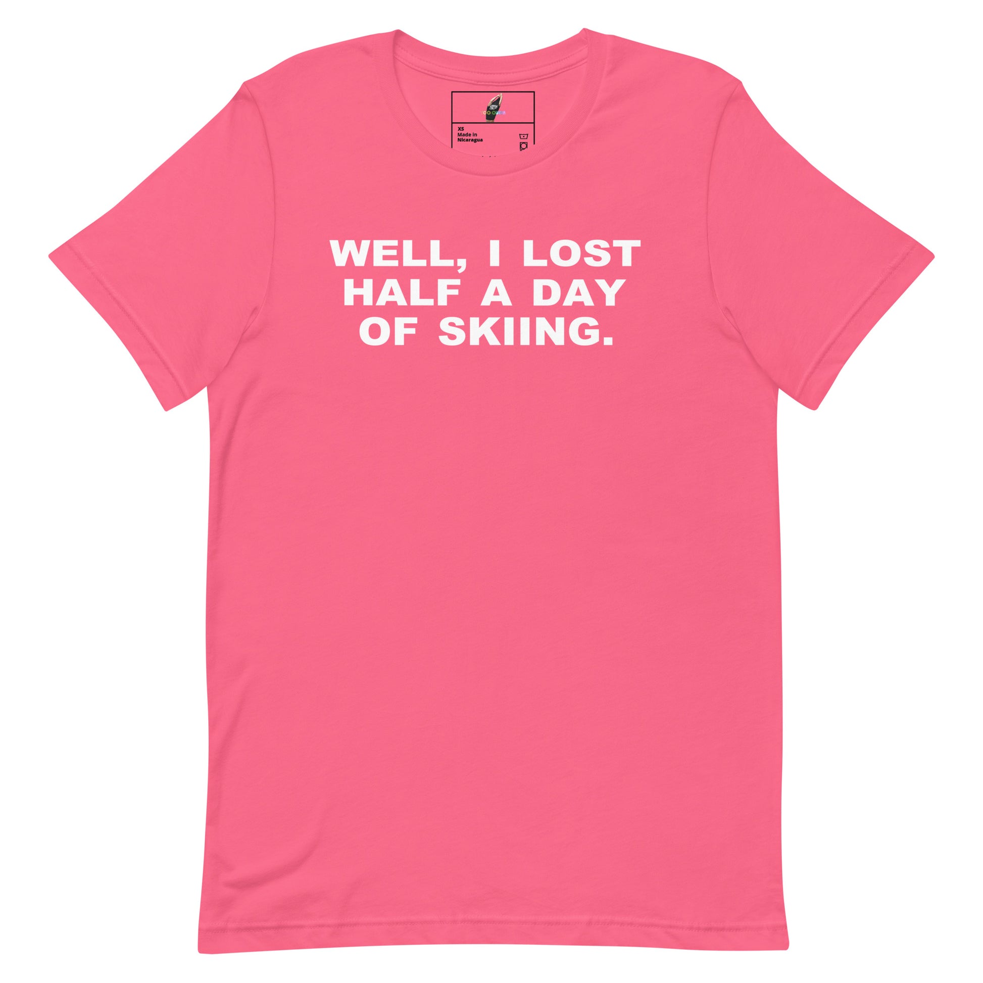 A bright pink short-sleeve crewneck t-shirt with the humorous text 'WELL, I LOST HALF A DAY OF SKIING.' printed in white capital letters across the chest, displayed on a clean white background.