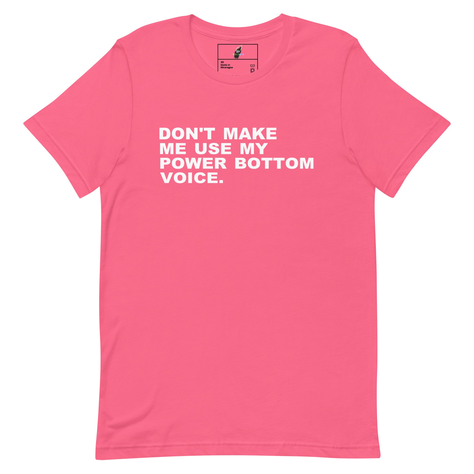 A pink short-sleeve crewneck t-shirt with the slogan 'DON'T MAKE ME USE MY POWER BOTTOM VOICE.' printed in white capital letters across the chest, displayed flat against a white background.