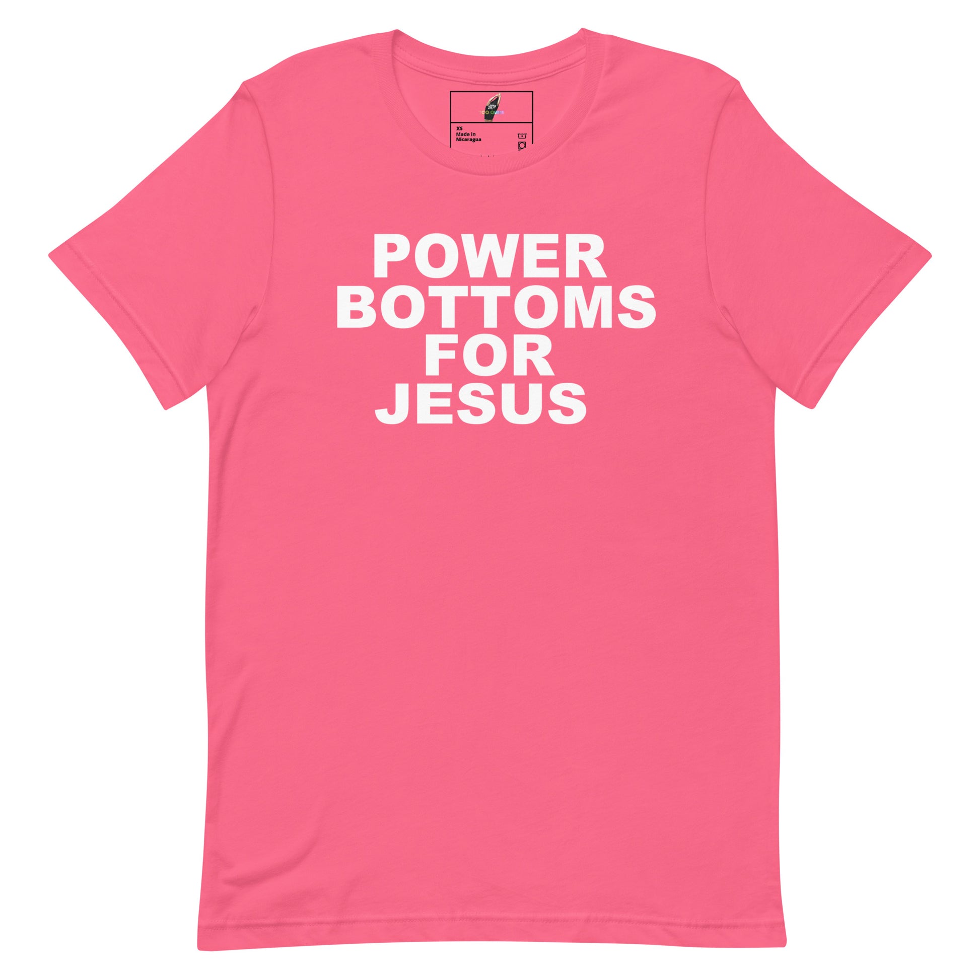 A pink short-sleeve crewneck t-shirt with bold white text on the front reading 'POWER BOTTOMS FOR JESUS'. The shirt is displayed flat against a clean white background, showing a small brand label inside the collar.