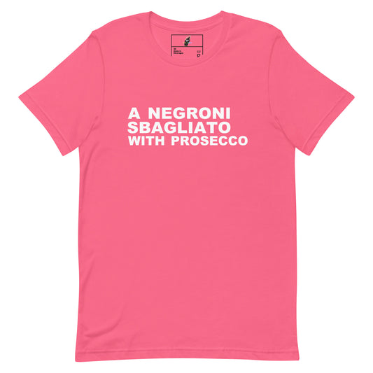 A pink short-sleeve crewneck t-shirt with bold white text on the chest reading 'A NEGRONI SBAGLIATO WITH PROSECCO'. The shirt is displayed flat against a solid white background, with a small brand label visible inside the collar.