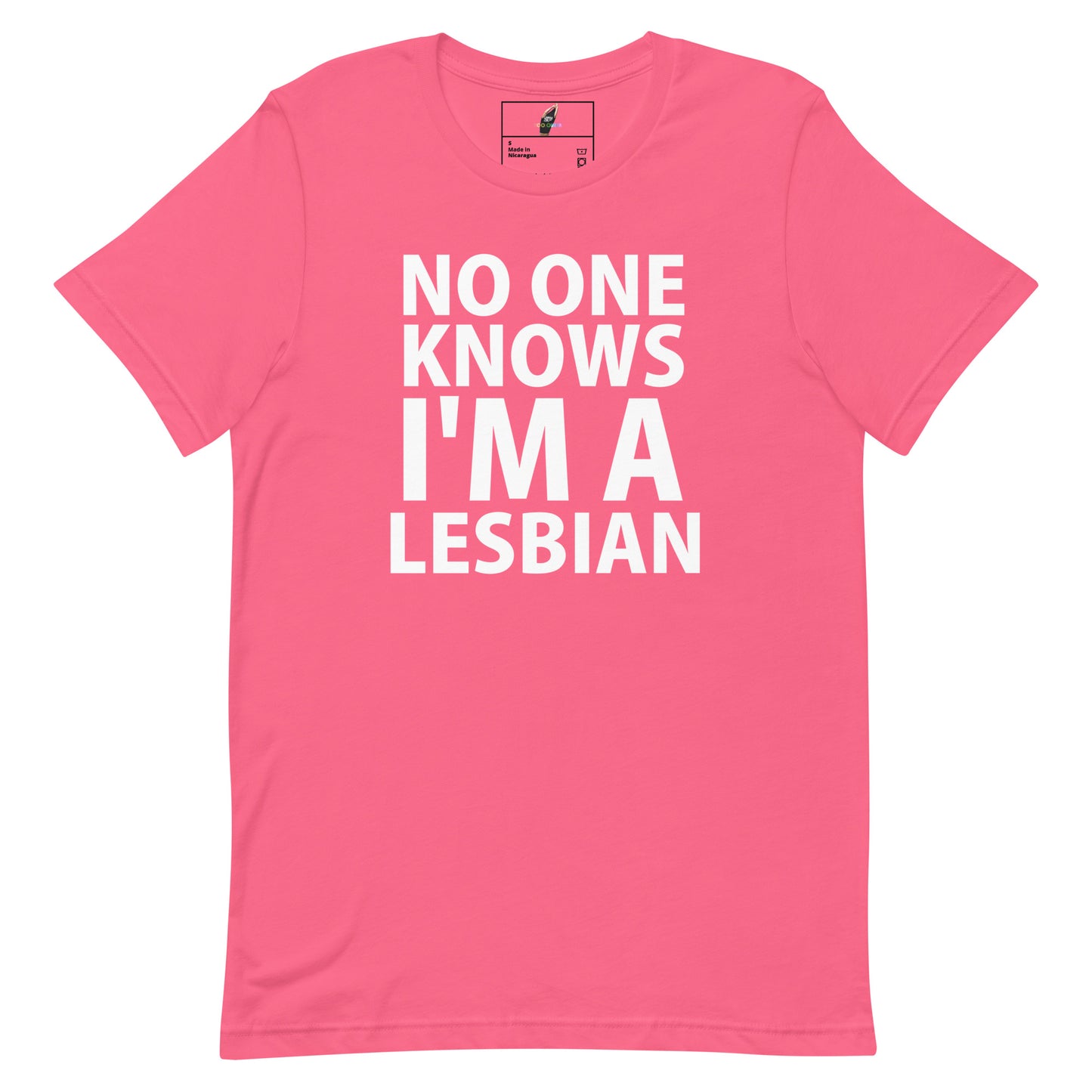A pink short-sleeve crewneck t-shirt with bold white text on the front reading 'NO ONE KNOWS I'M A LESBIAN'. The shirt is displayed flat against a solid white background, with a small brand label visible inside the collar.