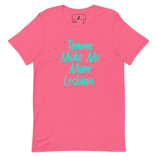 A pink short-sleeve crewneck t-shirt with the phrase 'Tempting Make Me More Lesbian' printed in a bright teal cursive font across the chest.