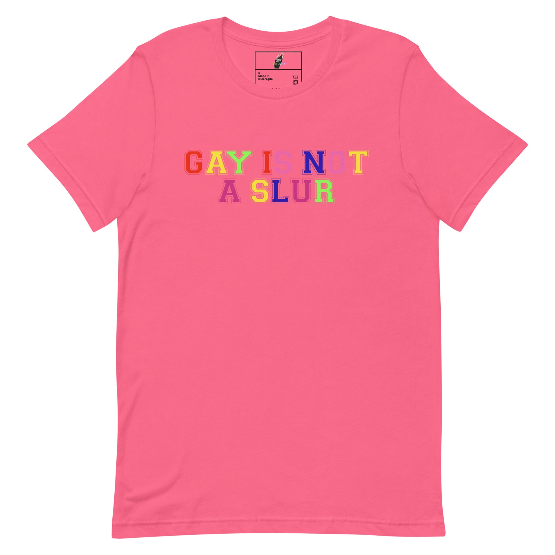 A pink short-sleeve crewneck t-shirt featuring the text 'GAY IS NOT A SLUR' printed across the chest in a rainbow-colored bubble font.
