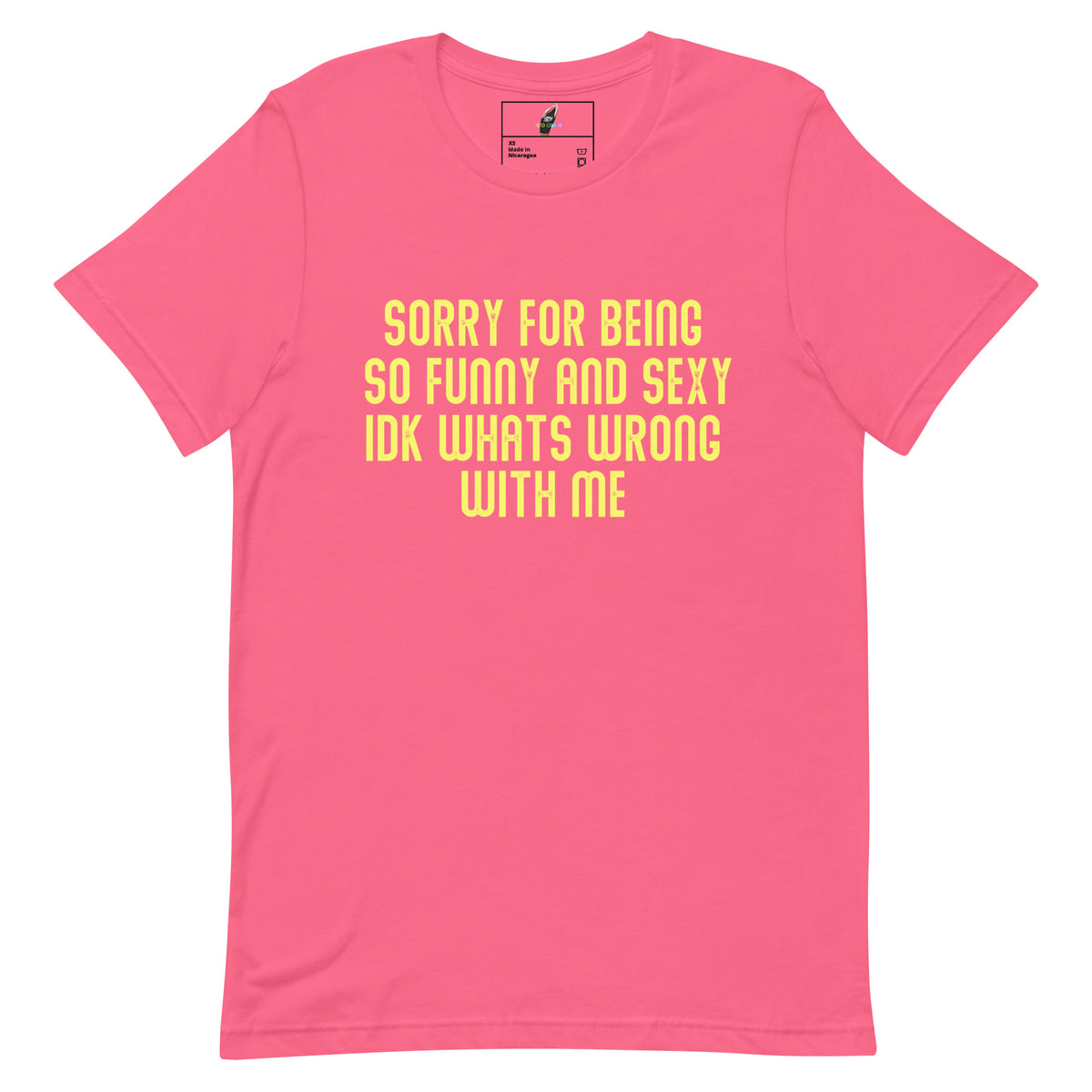 A pink short-sleeve crewneck t-shirt with yellow text on the front reading 'SORRY FOR BEING SO FUNNY AND SEXY IDK WHATS WRONG WITH ME'.