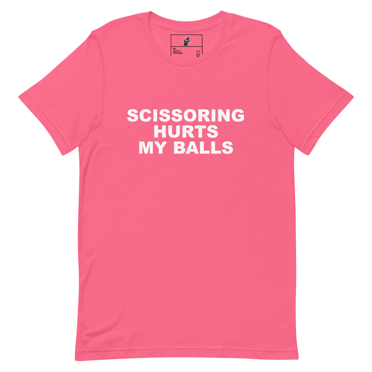 A pink short-sleeve crewneck t-shirt with bold white text on the front reading 'SCISSORING HURTS MY BALLS'. The shirt is displayed flat against a solid white background, with a small brand label visible inside the collar.