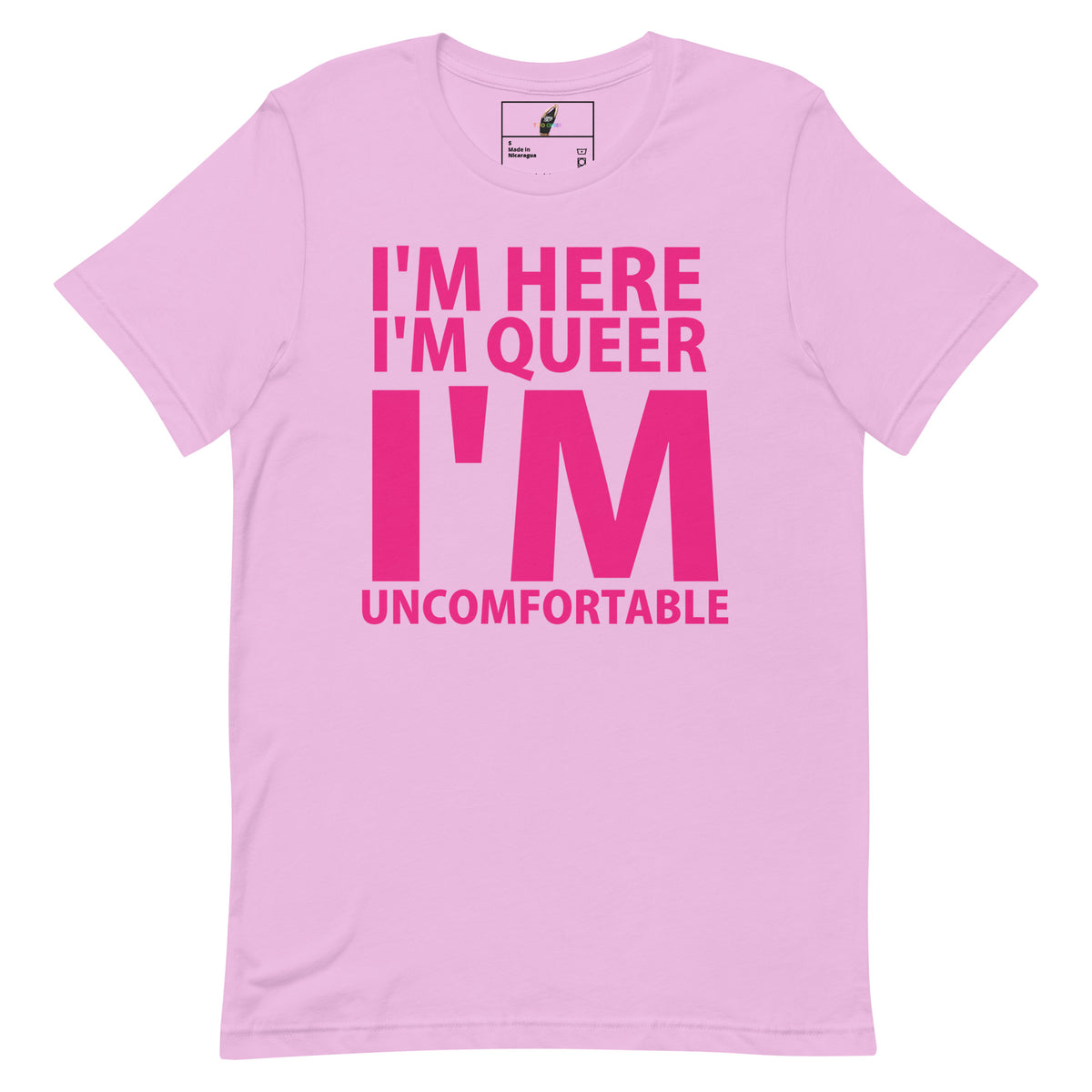 A light pink short-sleeve crewneck t-shirt with bold hot pink text on the front reading 'I'M HERE I'M QUEER I'M UNCOMFORTABLE'.