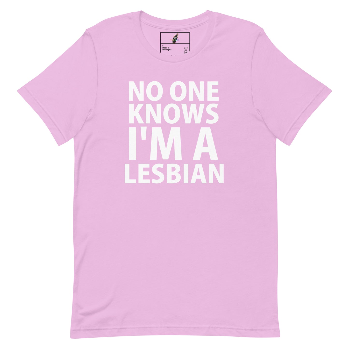 A light pink short-sleeve crewneck t-shirt with bold white text on the front reading 'NO ONE KNOWS I'M A LESBIAN'. The shirt is displayed flat against a solid white background, with a small brand label visible inside the collar.