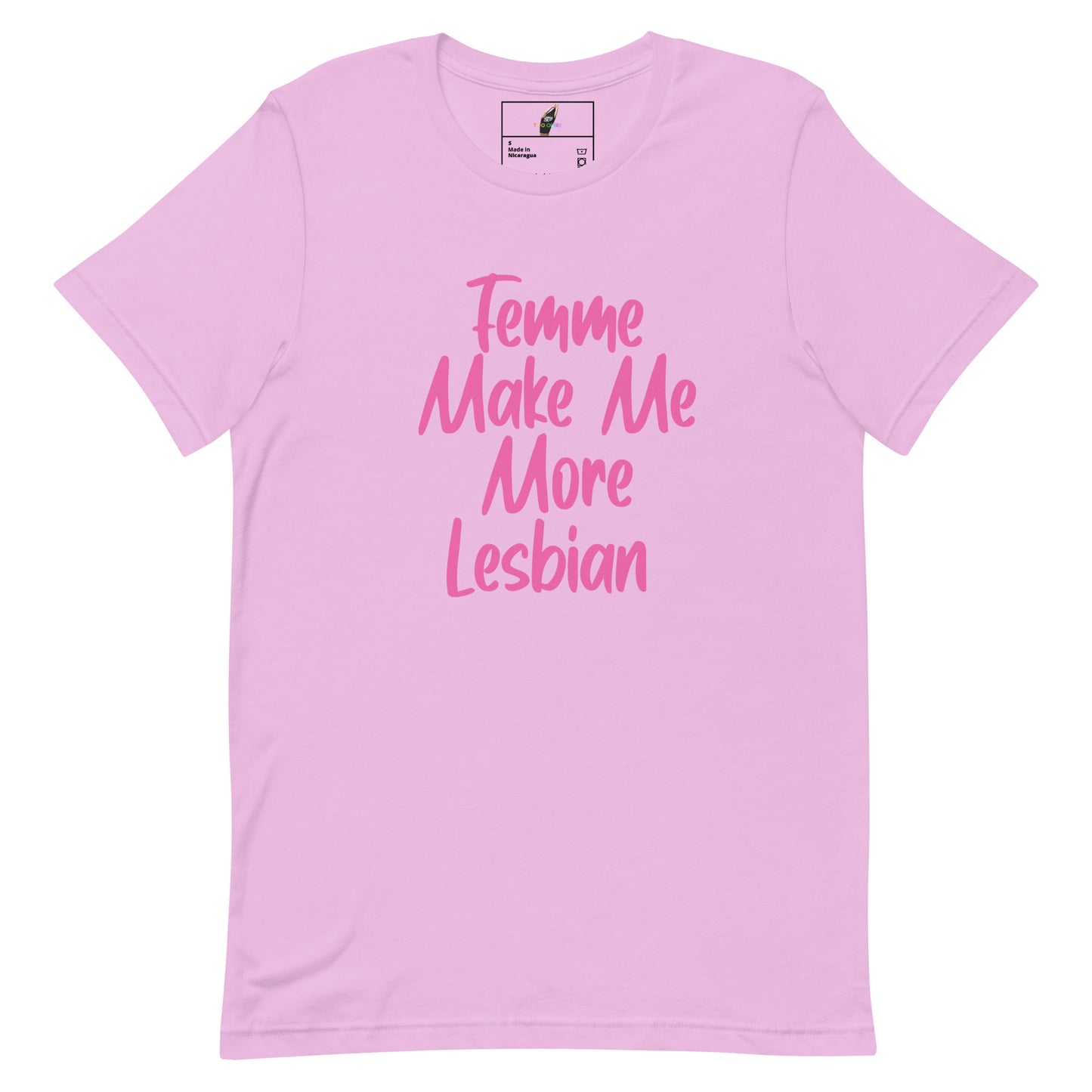 A light pink short-sleeve t-shirt with the phrase 'Femme Make Me More Lesbian' printed in a darker pink script font on the front, displayed against a solid white background.
