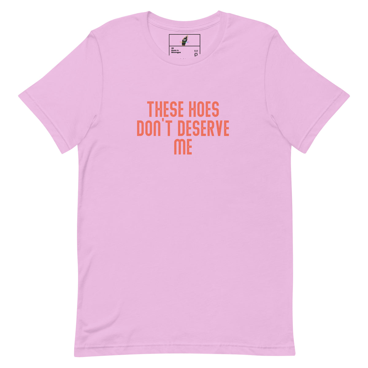 A light pink short-sleeve crewneck t-shirt with the text 'THESE HOES DON'T DESERVE ME' printed in orange across the chest, displayed on a clean white background.