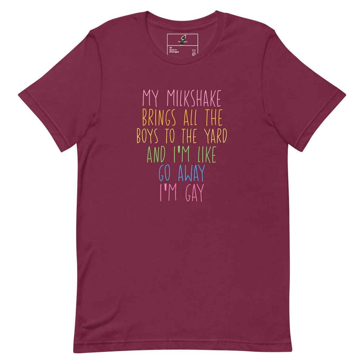 A maroon short-sleeve crewneck t-shirt with a colorful text graphic on the front that reads 'MY MILKSHAKE BRINGS ALL THE BOYS TO THE YARD AND I'M LIKE GO AWAY I'M GAY'.