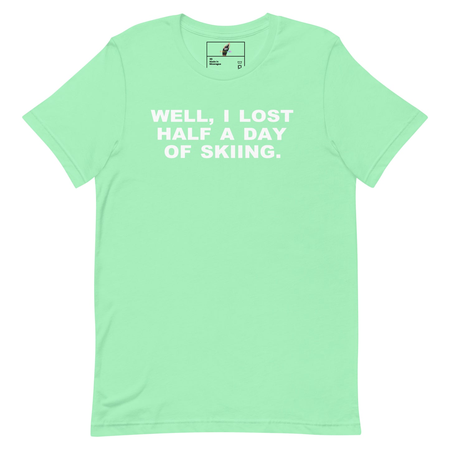 A mint green short-sleeve t-shirt with the phrase 'WELL, I LOST HALF A DAY OF SKIING.' printed in white block letters across the chest, displayed flat against a white background.
