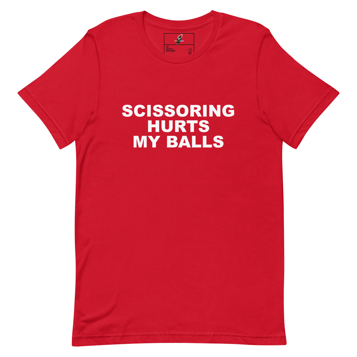 A red short-sleeve crewneck t-shirt with bold white text on the front reading 'SCISSORING HURTS MY BALLS'. The shirt is displayed flat against a solid white background, showing a small graphic label inside the collar.