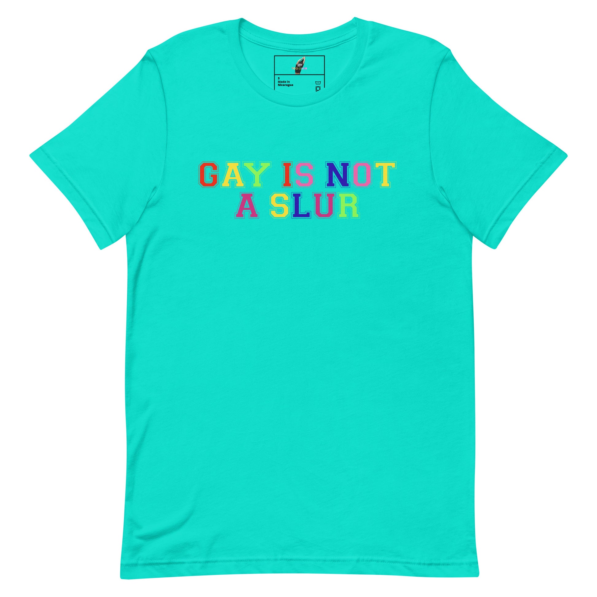 A turquoise short-sleeve crewneck t-shirt featuring the text 'GAY IS NOT A SLUR' printed across the chest in a rainbow gradient font. The shirt is displayed flat against a solid white background.