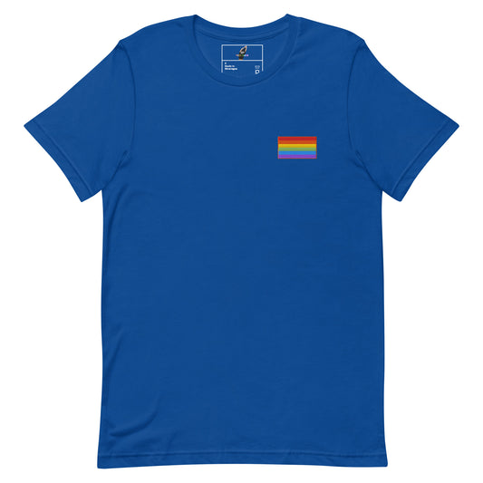 A royal blue short-sleeve crewneck t-shirt with a small rainbow pride flag graphic printed on the left chest, displayed on a clean white background.