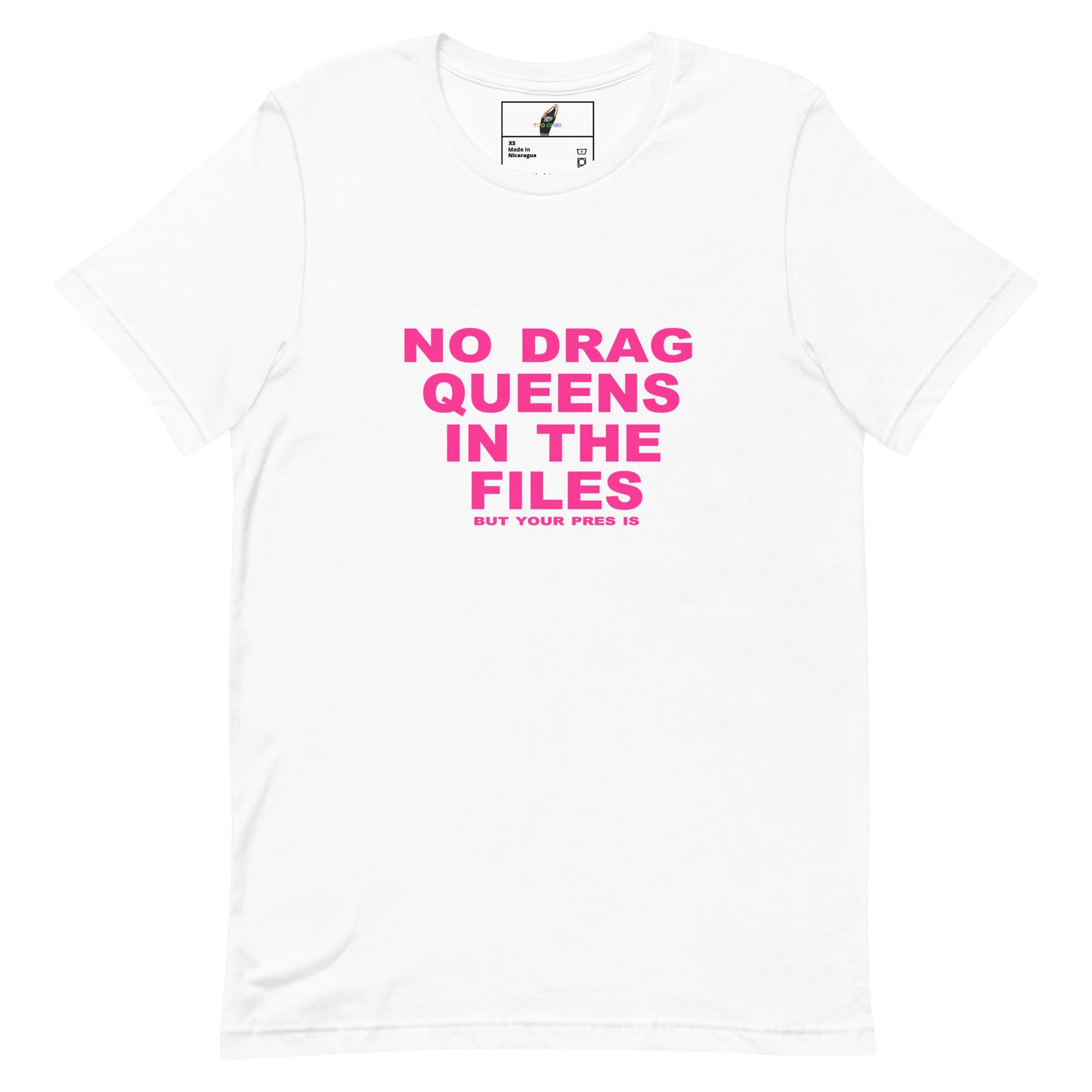 A white short-sleeve crewneck t-shirt with bold pink text on the front reading 'NO DRAG QUEENS IN THE FILES' and smaller text below reading 'BUT YOUR FREE IS'. The shirt is displayed flat against a clean white background.