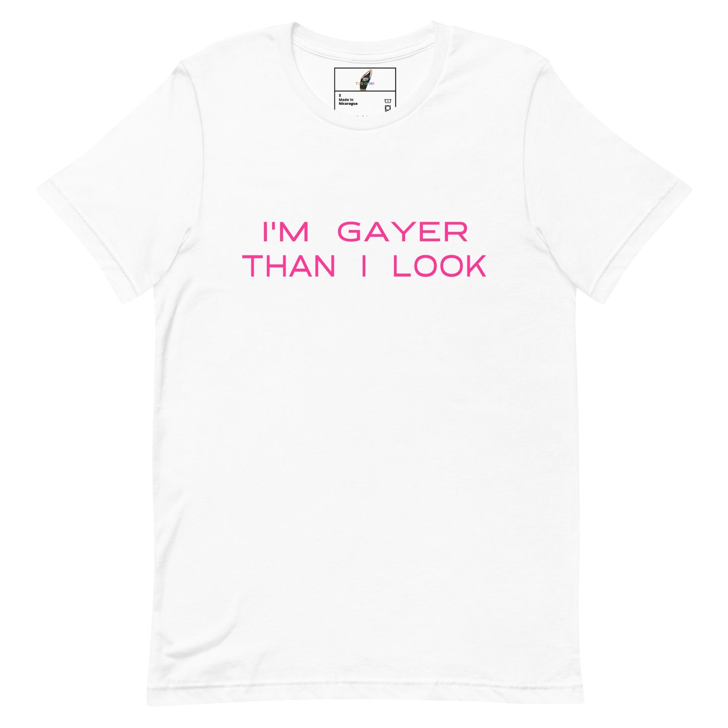 A white short-sleeve crewneck t-shirt with the phrase 'I'M GAYER THAN I LOOK' printed in bright pink across the chest. The shirt is displayed flat against a clean white background, with a small brand label visible inside the collar.