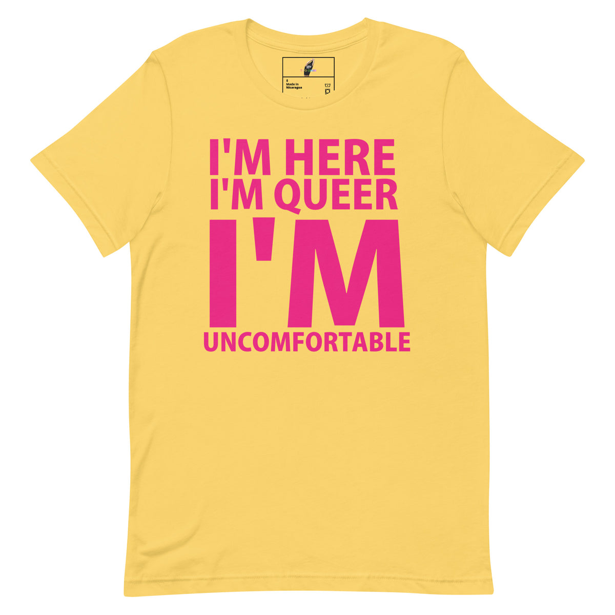 A yellow short-sleeve t-shirt with a bold pink graphic text print reading 'I'M HERE I'M QUEER I'M UNCOMFORTABLE' on the front, displayed against a solid white background.