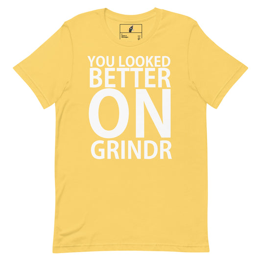A yellow short-sleeve t-shirt with bold white text on the front reading 'YOU LOOKED BETTER ON GRINDR'. The shirt is displayed flat against a solid white background, with a small brand label visible inside the collar.
