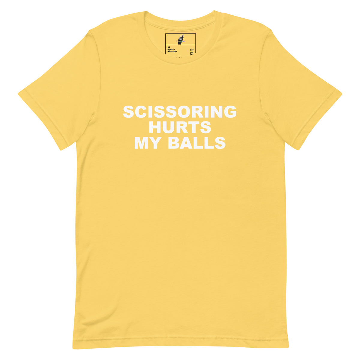 A yellow short-sleeve crewneck t-shirt with bold white text on the front reading 'SCISSORING HURTS MY BALLS'. The shirt is displayed flat against a clean white background, showing a small brand label inside the collar.